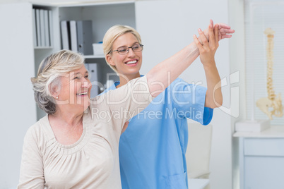 Nurse helping senior patient in exercising