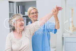 Nurse helping senior patient in exercising