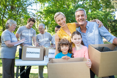 Happy family holding boxes and smiling at the camera