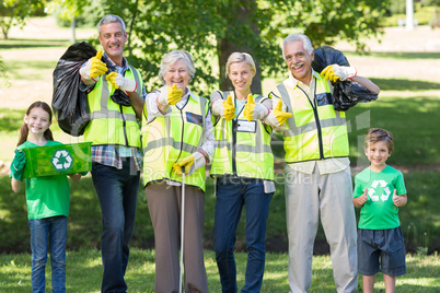 Happy family collecting rubbish with thumbs up