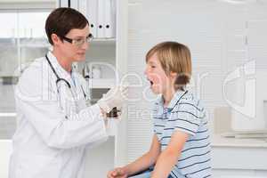 Doctor giving syrup to little boy