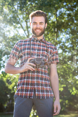 Handsome hipster using vintage camera