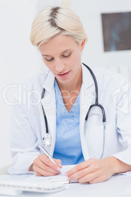 Doctor writing prescription at table