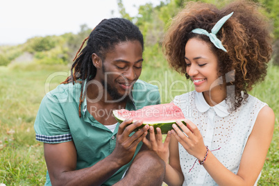 Young couple on a picnic eating watermelon