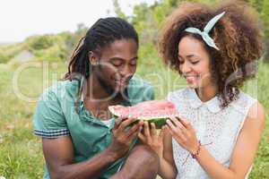 Young couple on a picnic eating watermelon