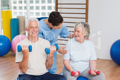 Female instructor with senior couple in gym