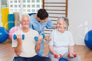 Female instructor with senior couple in gym