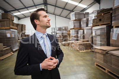 Warehouse manager standing hands together