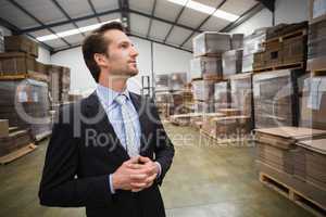 Warehouse manager standing hands together