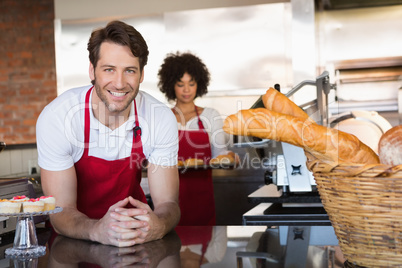 Portrait of smiling waiter in front of his colleague