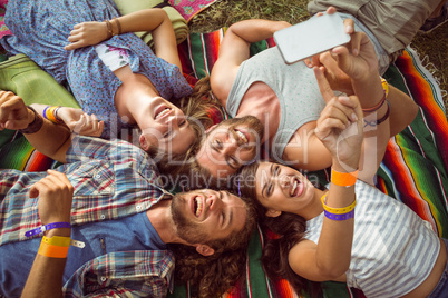 Happy hipsters lying on the grass