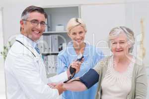 Doctor and nurse checking patients blood pressure
