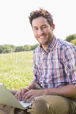 Young man using laptop in the countryside