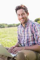 Young man using laptop in the countryside