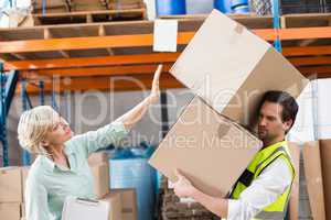 Worker balancing heavy cardboard boxes