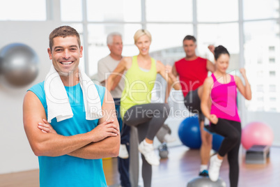 Fit man standing arms crossed at gym