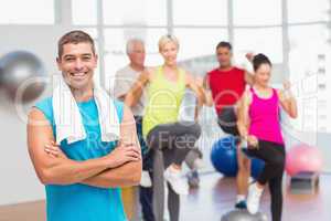 Fit man standing arms crossed at gym