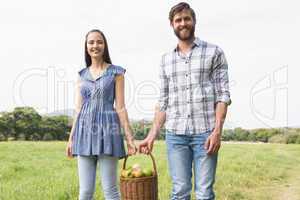 Couple holding basket full of apples