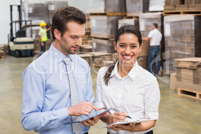 Smiling warehouse managers working together