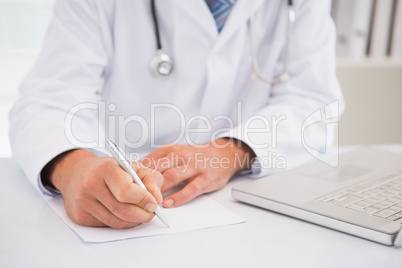 Doctor writing on a notepad