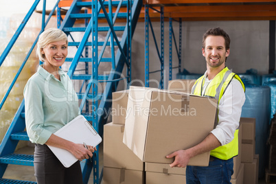 Worker holding box with manager holding clipboard