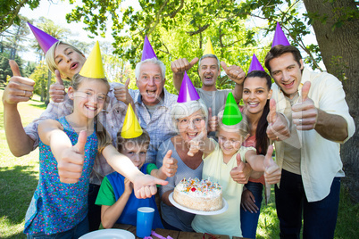 Happy family celebrating a birthday with thumbs up