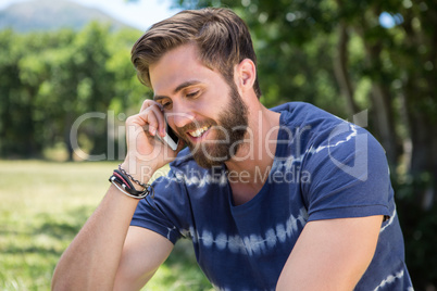 Handsome hipster on the phone in park