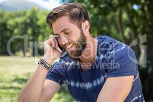 Handsome hipster on the phone in park