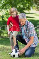 Happy father playing at the ball with his son