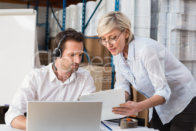 Warehouse manager showing something to her colleague