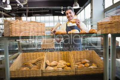 Smiling waiter in apron choosing bread