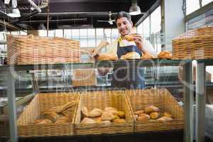 Smiling waiter in apron choosing bread