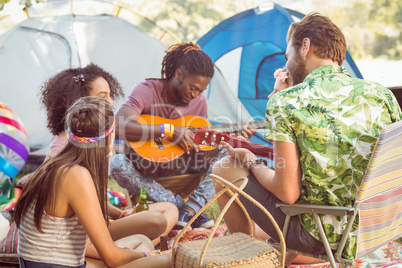 Hipster playing guitar for his friends