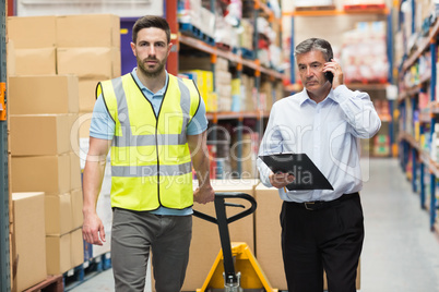 Worker walking with his manager over the phone
