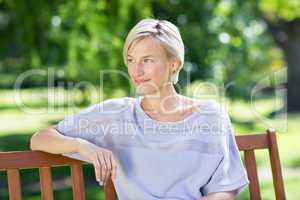 Smiling blonde sitting on a bench