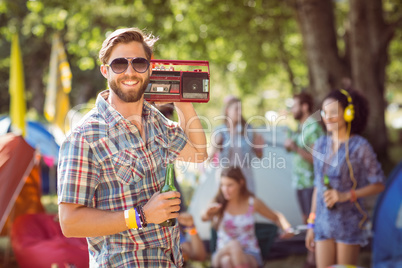 Handsome hipster holding retro cassette player