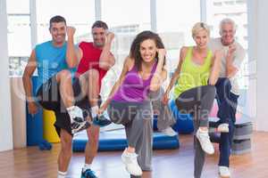People performing aerobics exercise in gym class