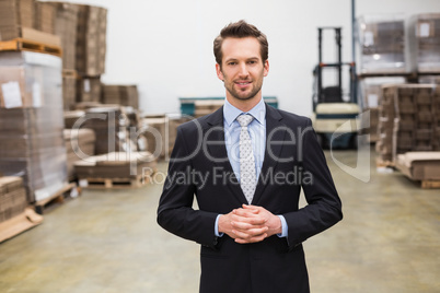 Warehouse manager standing hands together