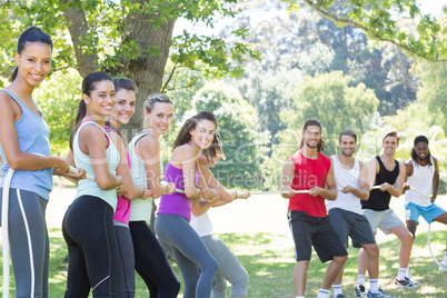 Fitness group playing tug of war