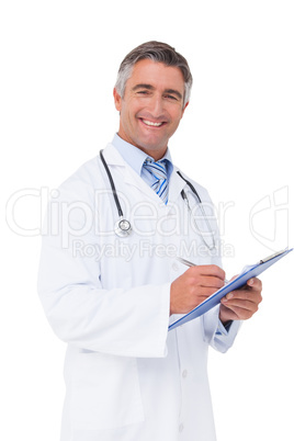 Happy doctor writing on clipboard