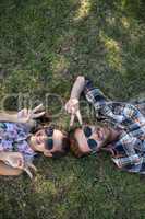 Young couple lying on grass smiling at camera