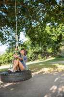 Pretty young woman in tire swing