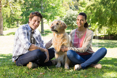 Happy couple with their dog in the park