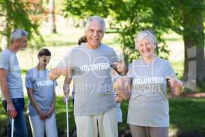 Happy volunteer senior couple smiling at the camera