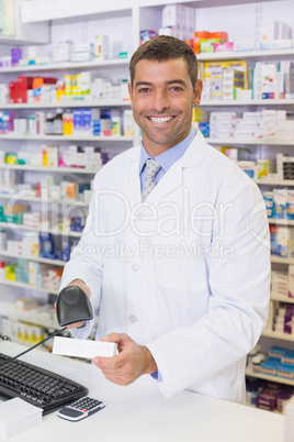 Handsome pharmacist scanning medicine box