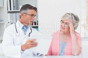 Doctor explaining prescriptions to tensed senior woman