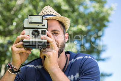 Handsome hipster using vintage camera