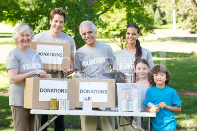 Happy volunteer family separating donations stuffs