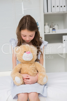 Little girl with her teddy bear in her harms