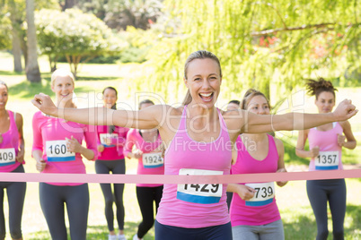 Smiling women running for breast cancer awareness